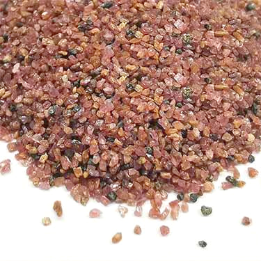 Close-up of SEPPE SGA 20/40 pink garnet abrasive grains for heavy-duty blasting